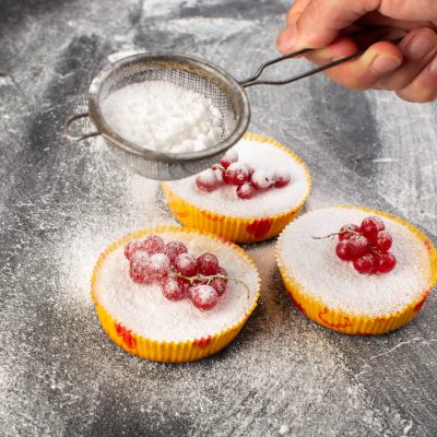 top-view-delicious-cranberry-cakes-baked-yummy-getting-sugar-powder-with-red-cranberries-top-grey-desk-cake-biscuit-sugar-sweet